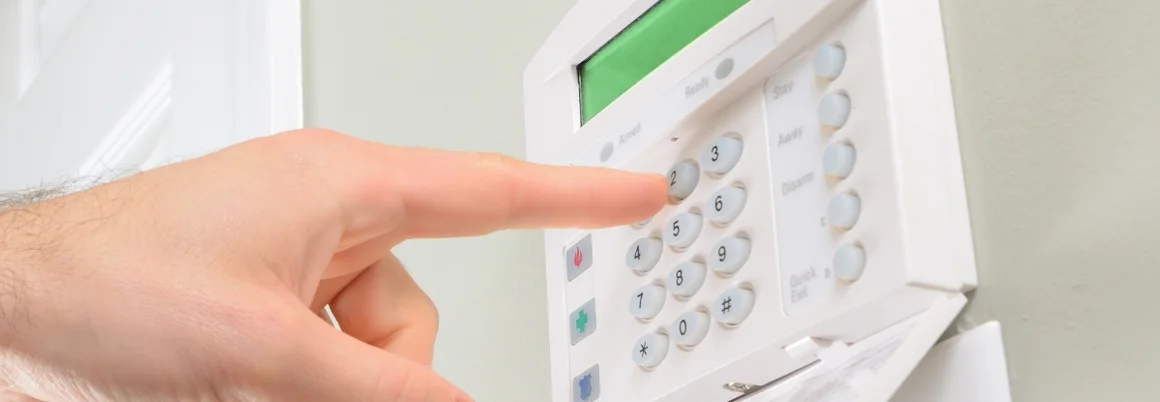 Eine Hand gibt einen Code auf einer Sicherheitsanlage ein